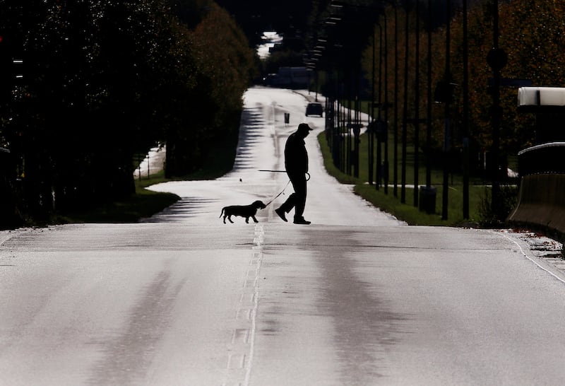 An elderly man and his Dachshund cross a long main road in the outskirts of Frankfurt, Germany, on a national holiday. Michael Probst / AP Photo