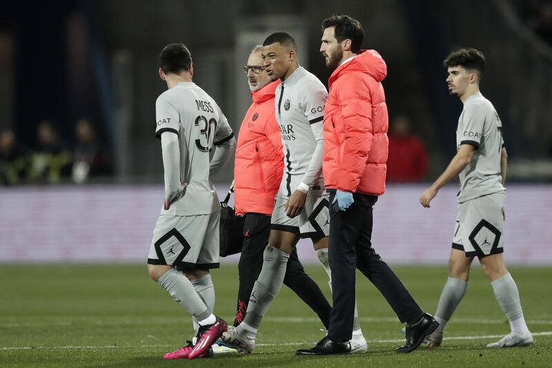 Paris Saint Germain's Kylian Mbappe talks to teammate Lionel Messi as he leaves the pitch due to an injury. EPA