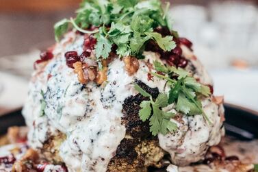 Roasted head of cauliflower served in spiced butter, yoghurt tahini tartare, walnuts and pomegranate, at Baron. Photo: Gates Hospitality