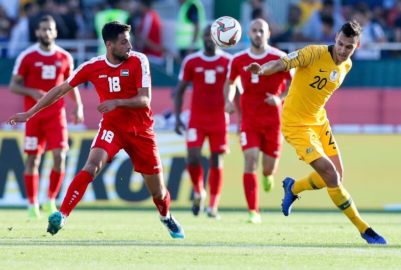 Australia's Trent Sainsbury, right, and Palestine's Day Dabbagh go for the ball. AP Photo