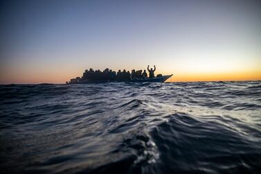 Migrants and refugees of different nationalities wait for assistance aboard an overcrowded wooden boat in the Mediterranean Sea. AP 