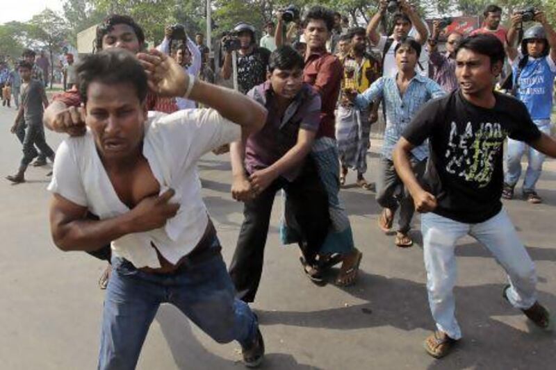 Bangladeshi Hefajat-e-Islam activists beat a man who is alleged to have helped police to identify protesters during a strike in Dhaka.