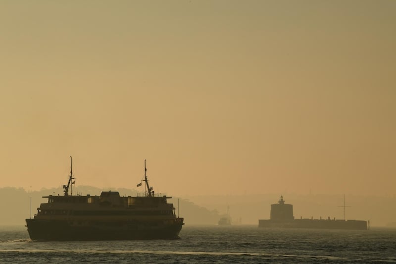 A commuter ferry moves through the thick smoke blanketing Sydney Harbour.