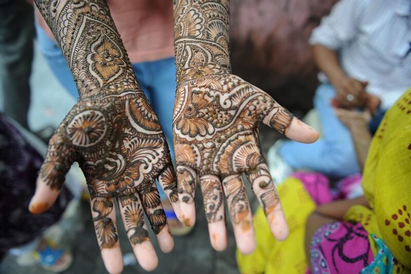 An Indian Muslim girl waits for her henna-decorated hands to dry at a roadside stall ahead of the Muslim festivities of Eid al-Fitr, in Mumbai, India. Indranil Mukherjee / AFP

