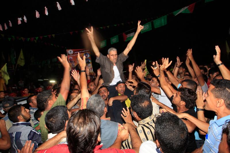 Freed Palestinian prisoner Ateya Abu Moussa (C), who was held by Israel for 20 years, is greeted by his relatives upon arrival at his family's house in Khan Younis in the southern Gaza Strip, early on August 14, 2013. Israel freed 26 Palestinian prisoners on August 14, hours before the two sides were to hold new direct peace talks amid a growing row over settlements.      AFP PHOTO / SAID KHATIB
 *** Local Caption ***  734266-01-08.jpg