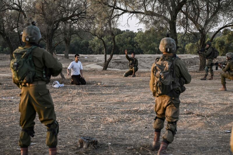 Israeli soldiers detain a man while on patrol near Kibbutz Beeri, near the Gaza Strip. AFP