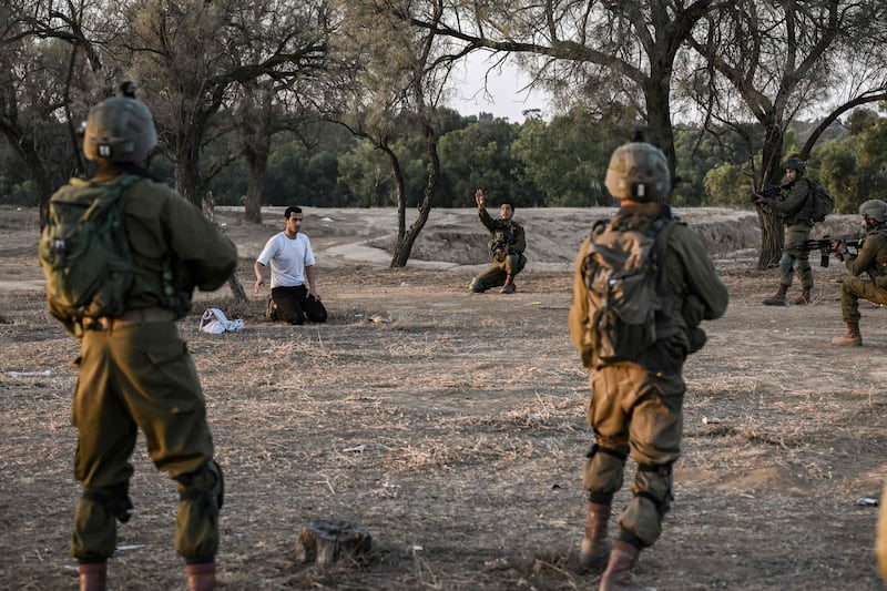 Israeli soldiers detain a man while on patrol near Kibbutz Beeri, near the Gaza Strip. AFP