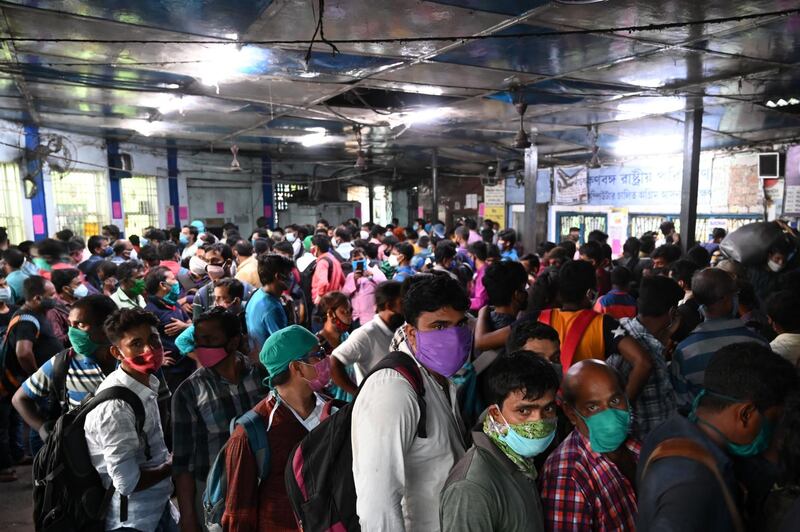 People queue to buy tickets to return home, at a bus station in Kolkata, after West Bengal's government announced a 15-day lockdown from May 16. AFP