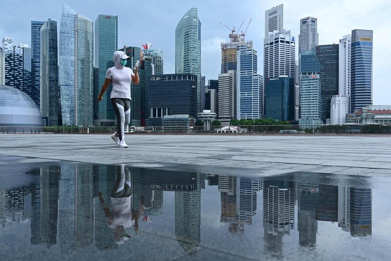 A woman, wearing a face mask as a preventive measure against the spread of the Covid-19 walks along the promenade at Marina Bay in Singapore. AFP