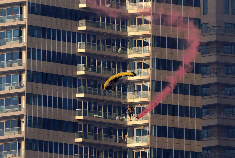 Parachutists perform in front of buildings at Dubai Marina. AFP