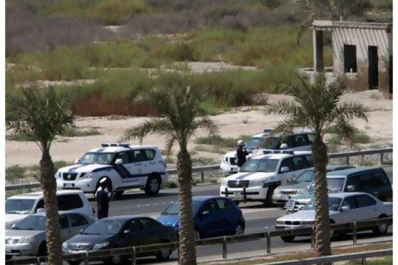 Police check cars yesterday along a highway heading into Manama, Bahrain. Traffic has been slowed to a crawl on many Bahrain highways after calls by pro-reform groups to flood the roads with slow-moving cars in a show of strength before parliamentary elections later this week. Hasan Jamali / AP Photo