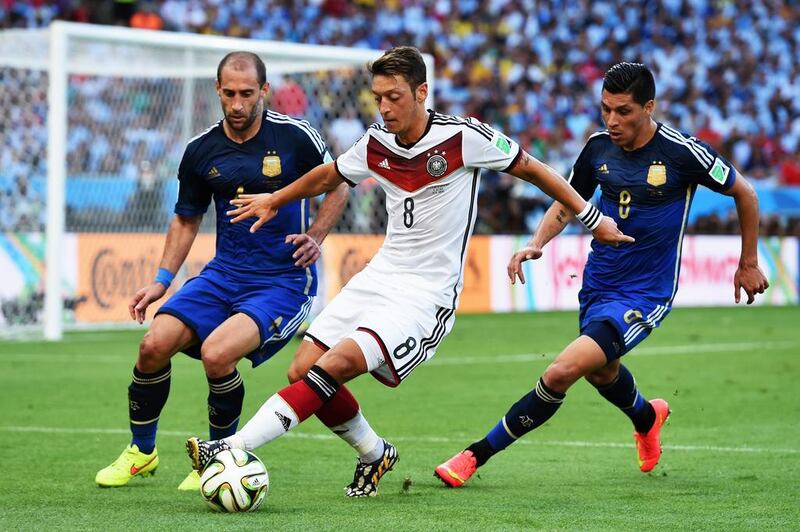 Mesut Ozil of Germany controls the ball against Pablo Zabaleta, left, and Enzo Perez of Argentina. Matthias Hangst / Getty Images