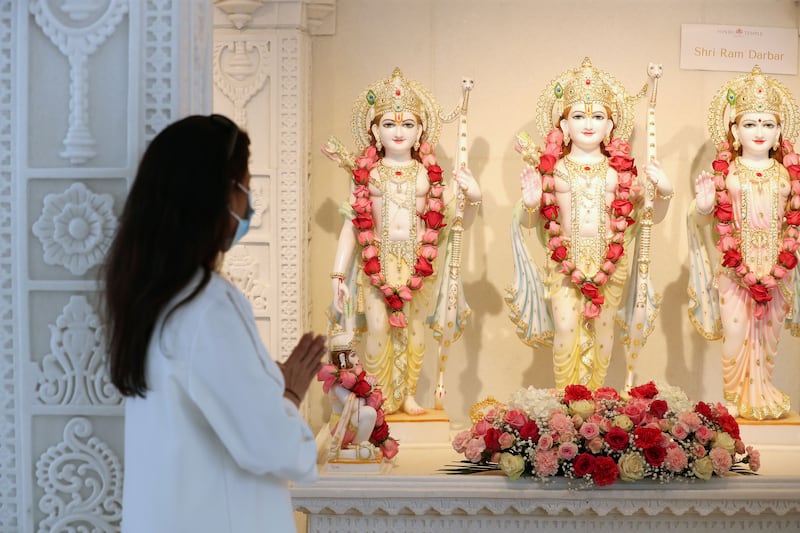A devotee files past Hindu deities during a soft opening. Chris Whiteoak / The National