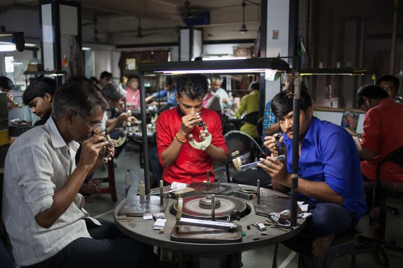 An employee inspects a polished diamond at the Virani Gems workshop in the city of Surat in Gujarat, India. Photographer: Karen Dias/Bloomberg