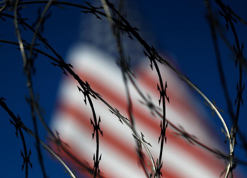 Barbed wire lines the top of a wall at the San Ysidro port of entry in San Diego. AP
