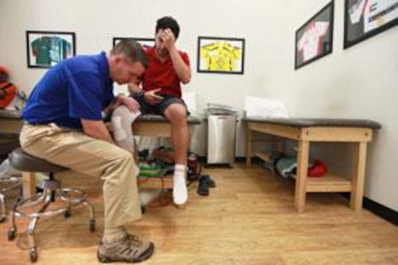 David Baston treats Ayman Helal at the Abu Dhabi Knee and Sports Medicine Centre.