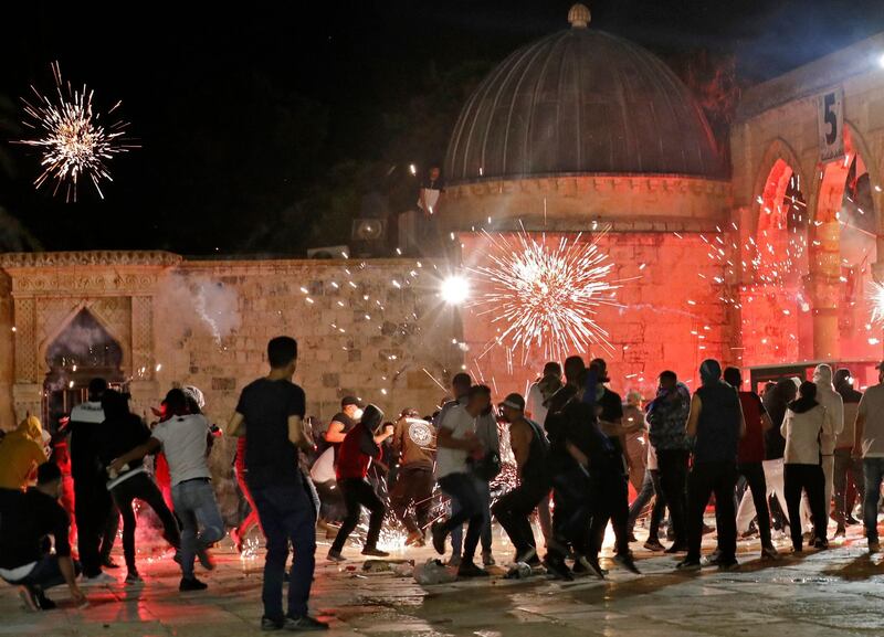 TOPSHOT - Stun grenades burst in the air amid clashes between Palestinian protesters and Israeli security forces at the al-Aqsa mosque compound in Jerusalem, on May 7, 2021. / AFP / Ahmad GHARABLI
