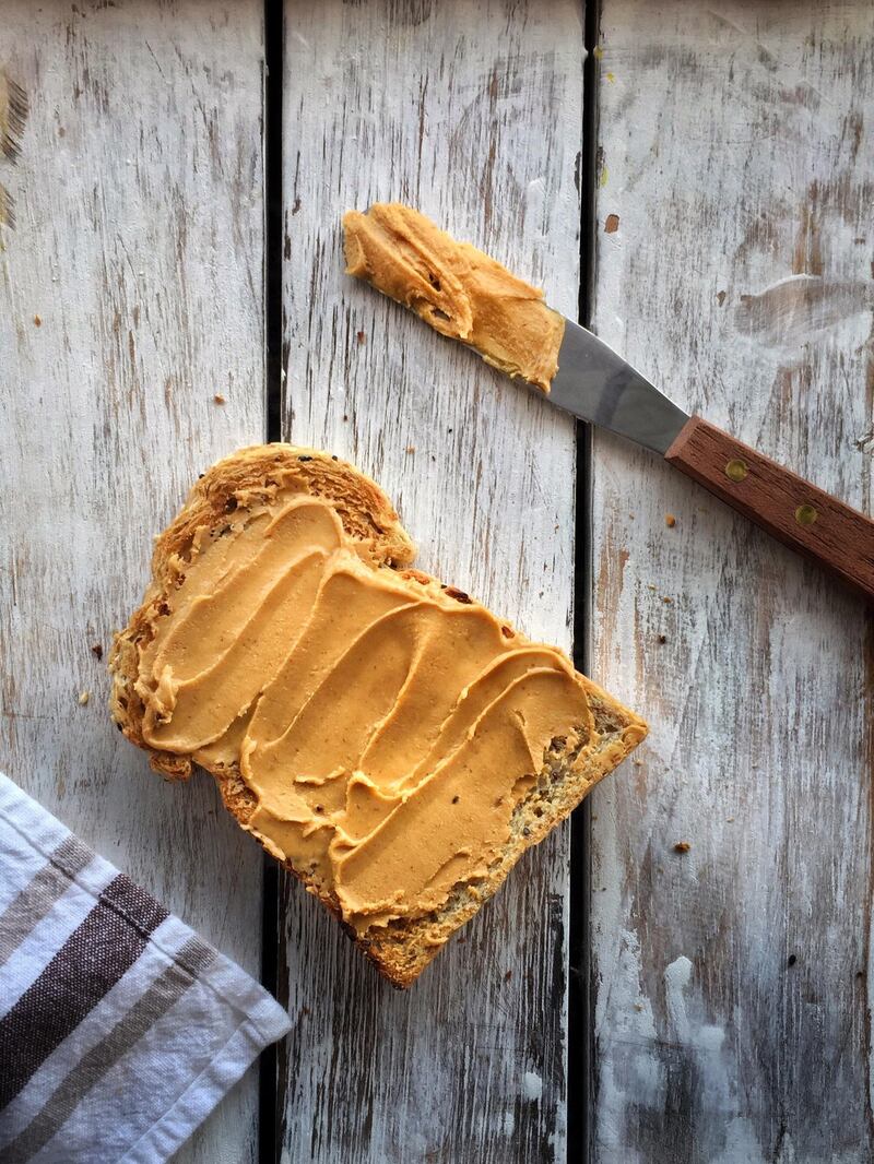 Toasted Bread With Peanut Butter On Table. Getty Images