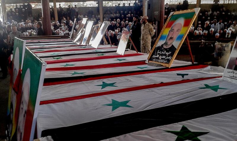 epa06911180 A handout photo made available by Syrian Arab news agency (SANA) shows Druze clerics and citizens sit next to the coffins during a massive popular funeral ceremony for the martyrs of the attacks that targeted the al-Sweida province, southern Syria, 26 July 2018. According to reports on 25 July 2018, 220 citizens were killed and others were injured in suicide bombing attacks at al-Sweida city synchronizing with Islamic State (IS) attacks on a number of villages in the eastern and northern countryside of the province.  EPA/SANA HANDOUT HANDOUT  HANDOUT EDITORIAL USE ONLY/NO SALES