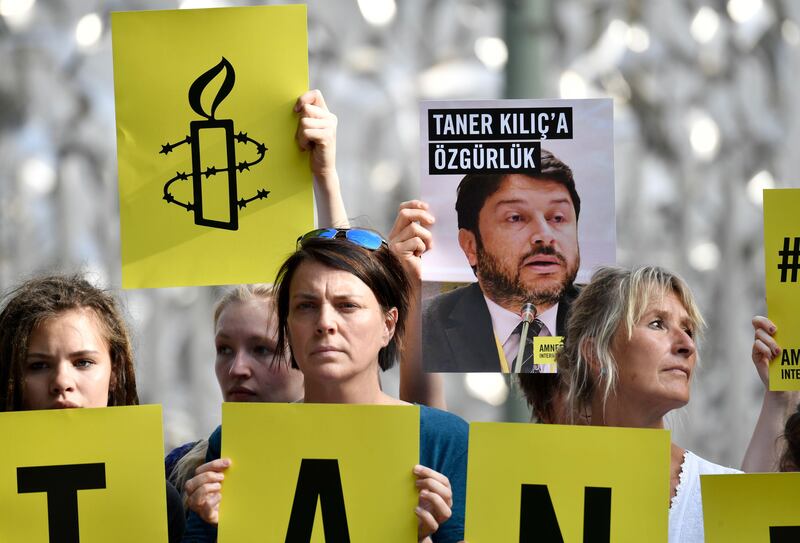 Activists of Amnesty International stage a protest against the detention of the head of Amnesty International in Turkey, Taner Kilic, in front of the Turkish Embassy in Berlin on June 15, 2017.
Taner Kilic was arrested in the Turkish province of Izmir along with 22 other lawyers on June 6, 2017 and has been charged with membership of a terrorist organisation and remanded in custody pending trial  / AFP PHOTO / John MACDOUGALL