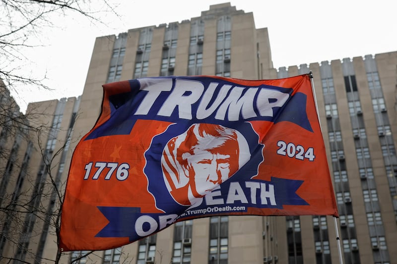 A flag with an image of Mr Trump waves outside the Manhattan Criminal Courthouse. Reuters