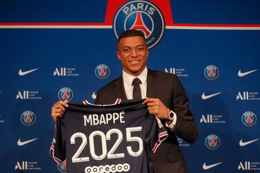 PSG striker Kylian Mbappe shows his jersey during a press conference Monday, May 23, 2022 at the Paris des Princes stadium in Paris.  Kylian Mbappé's decision to reject Real Madrid and commit to Paris Saint-Germain for three more seasons marks the start of a large rebuilding project at the French league champion.  (AP Photo / Michel Spingler)
