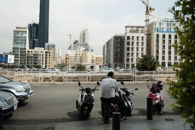 A pedestrian sits on a street bollard beside ancient ruins and office blocks in Beirut, Lebanon, on Thursday, Sept. 12, 2019. With one of the world’s biggest debt burdens, the government has pledged measures to reduce its deficit and implement reforms, including fixing the ailing electricity sector. Photographer: Patrick Mouzawak/Bloomberg