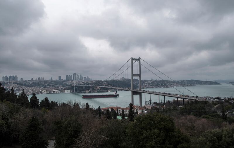 A cargo ship sails under a bridge on the Bosphorus in Istanbul. EPA