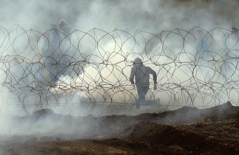 A Palestinian protester runs away from the border fence between Israel and the Gaza Strip. AFP