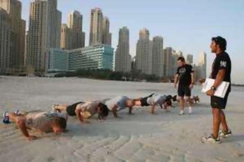 Dubai, 4th June 2008.  (Left,standing)) Corey Oliver( Director of Fitness and Operations-Physical Advantage ) and (Right,standing)Anthony Mamodesen (Instructor)with the participants of a military style exercises, held at the Jumeirah coastline on Jumeirah Beach Residence. (Jeffrey E. Biteng / The National )  Editors Note: Plenty of shots need to trim down to top 7. *** Local Caption ***  JB0215-Bootcamp.jpgna06 boot camp1.jpg