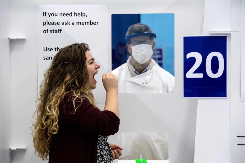 A student from the University of St. Andrews takes a swab for a lateral-flow test in a mass COVID-19 testing centre, set up in the University's sports hall in St. Andrews, eastern Scotland on November 27, 2020, to determine if they are able to travel home for the Christmas break.  / AFP / Andy Buchanan

