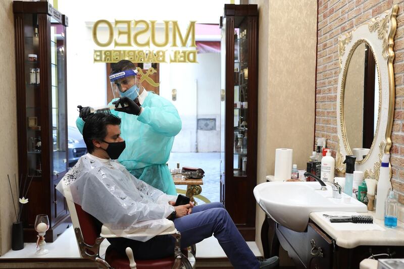 A hairdresser, wearing a protective face mask, works in a barber shop in Rome, Italy. Bloomberg