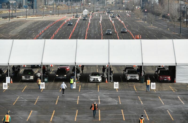 Cars make their way through lines of cones as they arrive for a UCHealth drive-up mass Covid-19 vaccination event in the parking lots of Coors Field in Denver, Colorado. The Denver Post via AP
