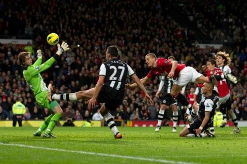 Newcastle's goalkeeper Tim Krul, left, saves a header by Manchester United's Nemanja Vidic, center right, in the last few minutes of the match at Old Trafford.