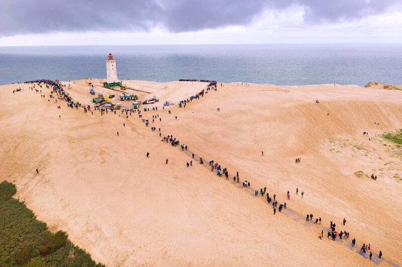 Aerial view shows people looking on as the lighthouse in Rubjerg Knude is being moved away from the coastline on October 22, 2019 between Lonstrup and Lokken, Jutland, Denmark. AFP