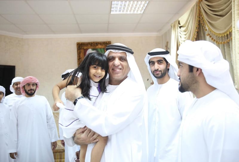 Sheikh Saud bin Saqr, Ruler of Ras Al Khaimah, carries a girl while visiting the family members of an Emirati soldier who died in action, in February 2017. Wam