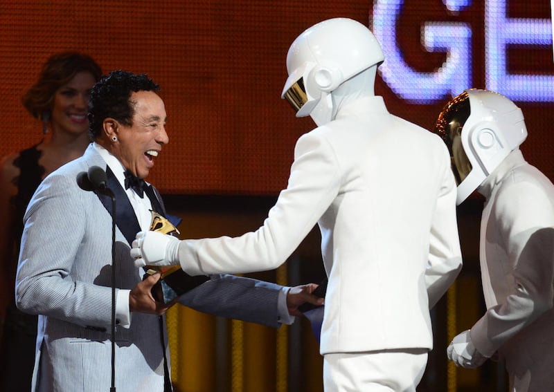 Smokey Robinson (L) congratulates Daft Punk for their Grammy For Record Of The Year "Get Lucky" on stage during the 56th Grammy Awards at the Staples Center in Los Angeles, California, January 26, 2014. AFP PHOTO FREDERIC J. BROWN (Photo by FREDERIC J. BROWN / AFP)