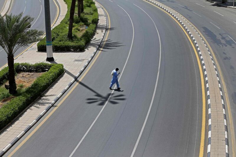 A man checks his phone as he crosses an empty street in Saudi Arabia's holy city of Makkah on April 3, 2020. AFP