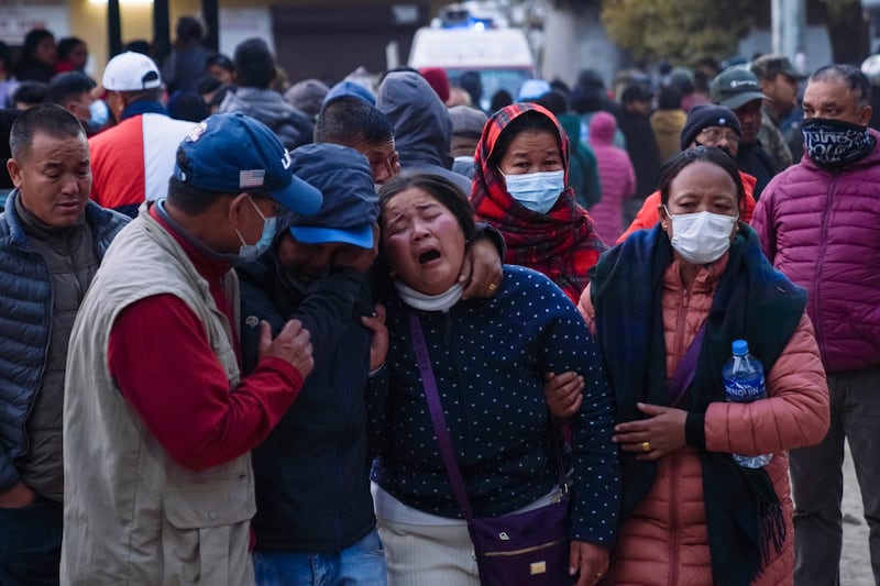 Relatives gather as the body of a relative killed on the Yeti Airlines flight is taken to a hospital in Pokhara, Nepal. AP