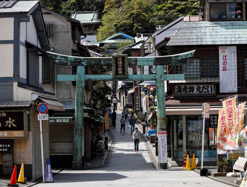 Visitors wearing protective face masks walk on a sightseeing spot on Enoshima Island after government asked citizens to be more diligent on social distancing under the state of emergency in Fujisawa, south of Tokyo, Japan. Reuters