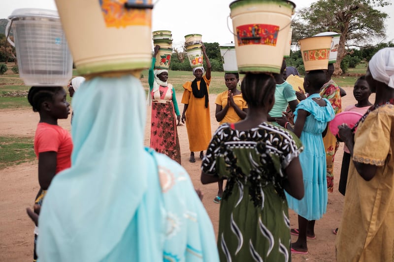 The family of a bride celebrate in the Nuba Mountains as they prepare to deliver a dowry of porridge and a fermented beverage known as merisa.