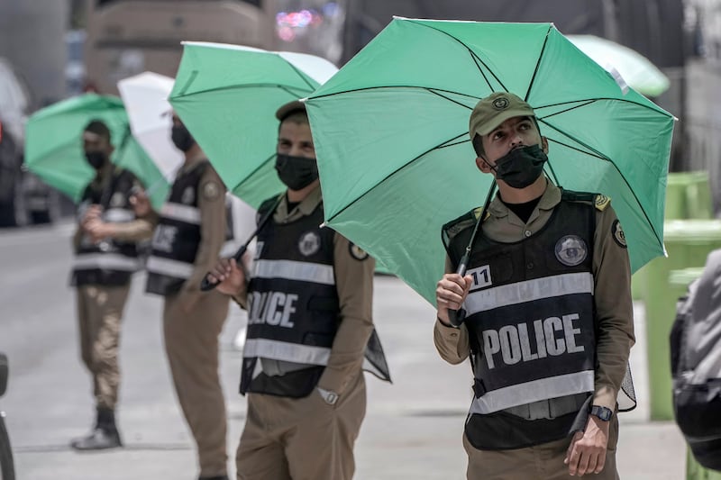 Saudi policemen under umbrellas at the Mina tent camp. AP 