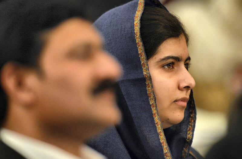 Pakistani activist for female education and Nobel Peace Prize laureate Malala Yousafzai (C) and her father Ziauddin Yousafzai listen to speeches during an event to commemorate the Peshawar school massacre in Birmingham, north England on December 14, 2015. On December 16, 2014 Taliban gunmen coldly slaughtered more than 150 people, most of them children, at an army-run school in Peshawar.  AFP PHOTO / PAUL ELLIS (Photo by PAUL ELLIS / AFP)