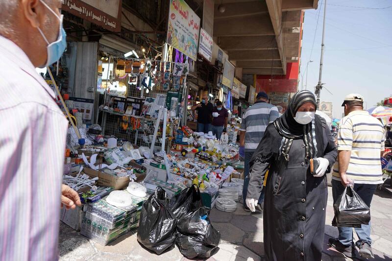 Iraqis walk along a street in the capital Baghdad. AFP