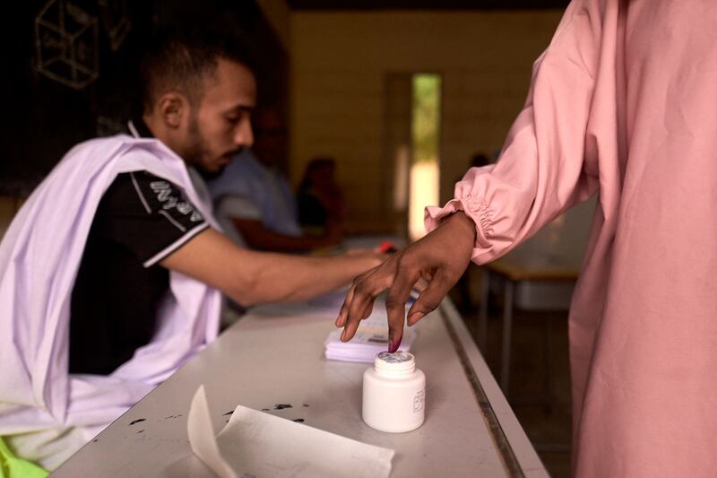 A voter dips his finger in an ink pot after casting his ballot at a polling station in Nouakchott, Mauritani. AFP