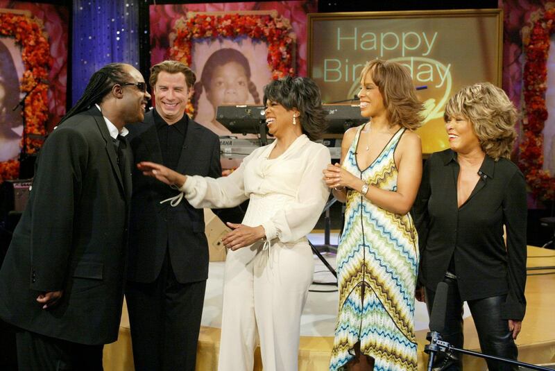 epa00126225 Oprah Winfrey (C) laughs as ?The Oprah Winfrey Show? celebrates Oprah's 50th Birthday with a surprise bash and a star studded line-up, including guest appearances by Stevie Wonder, from left, John Travolta, Gayle King and Tina Turner, Thursday, 29 January 2004, in Chicago.  EPA/GEORGE BURNS