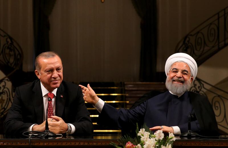 Iran's President Hassan Rouhani, right, laughs during a joint press conference with Turkey's President Recep Tayyip Erdogan following their meeting at the Saadabad Palace in Tehran, Iran, Wednesday, Oct. 4, 2017. With Erdogan by his side, Rouhani pledged Wednesday that they would ensure borders in the region remain unchanged after the recent Kurdish independence referendum in Iraq. (Presidency Press Service/Pool Photo via AP)