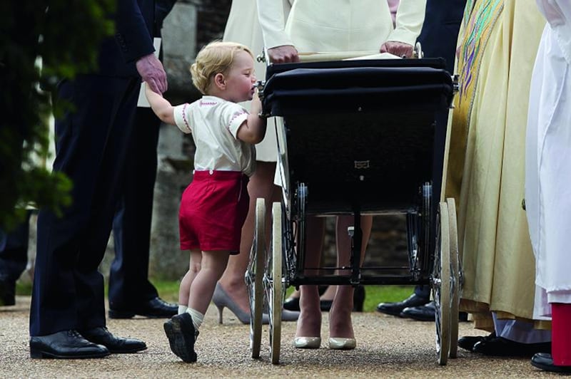 Britain’s Prince George looks into the pram of his sister, Princess Charlotte, after her christening in July in Norfolk. Matt Dunham / Reuters / July 5, 2015