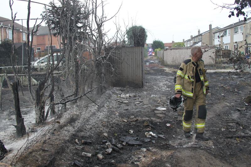 Firefighters in Maltby, after a fire started on scrubland before spreading to outbuildings, fences and homes in South Yorkshire. PA