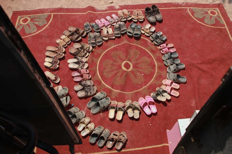 The shoes of displaced Syrian children are left outside a bus converted into a classroom.